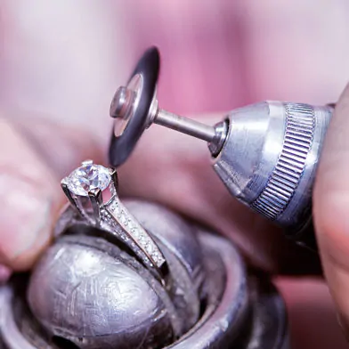 A jeweller polishing a diamond ring.